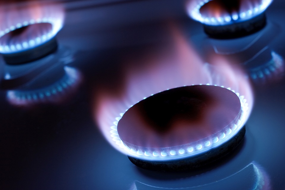 side view of a young female smiling and interacting with boiler dial controls
